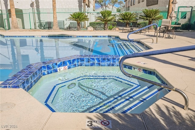 view of swimming pool featuring a patio area and a community hot tub