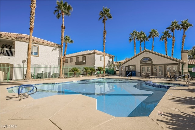 view of swimming pool featuring a hot tub and a patio area