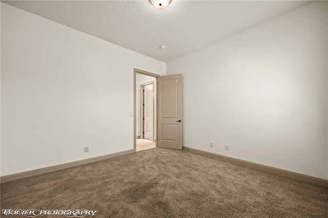 carpeted empty room with lofted ceiling and a textured ceiling