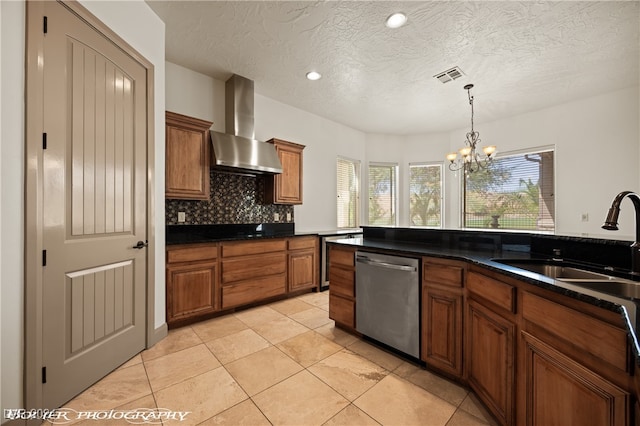 kitchen featuring wall chimney range hood, sink, dishwasher, a textured ceiling, and an inviting chandelier