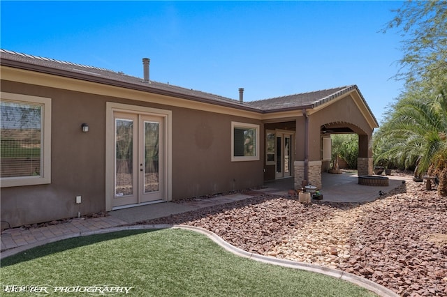 rear view of property with a patio, french doors, and a lawn