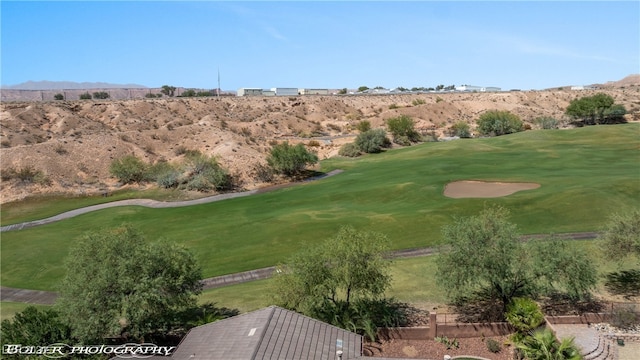 view of property's community with a mountain view and a lawn