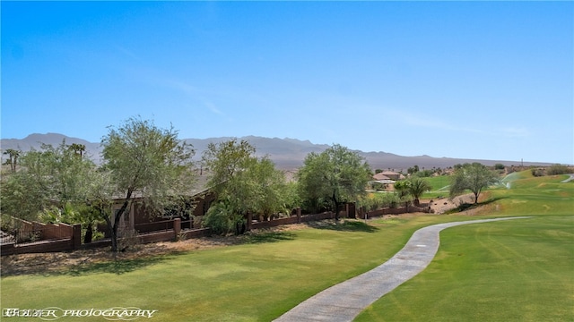 surrounding community with a yard and a mountain view