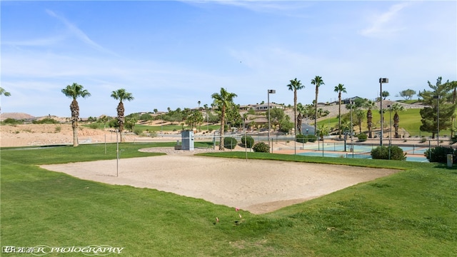 view of community featuring a yard, a swimming pool, and volleyball court