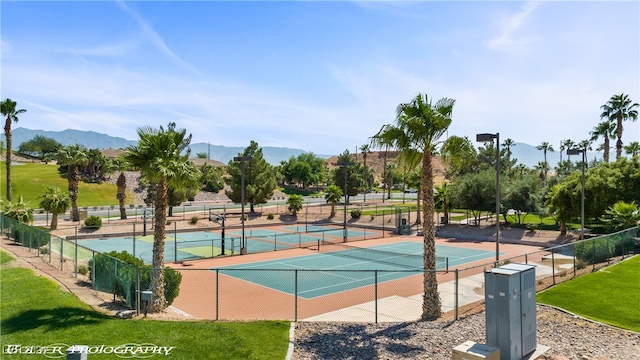 view of sport court with a yard and a mountain view