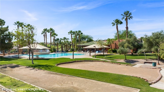 view of property's community with a pool and a lawn