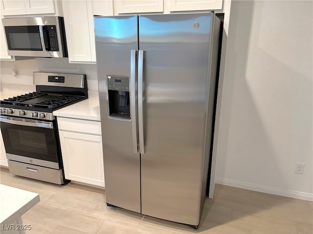 kitchen featuring stainless steel appliances and white cabinetry