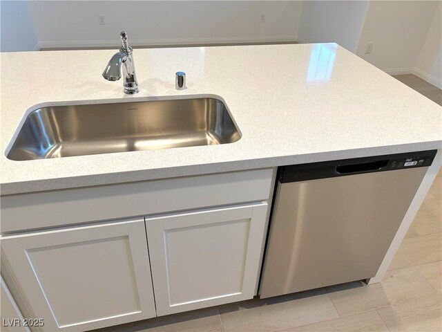 kitchen featuring white cabinets, dishwasher, and sink