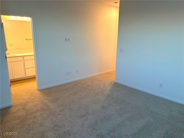 spare room featuring light carpet and sink