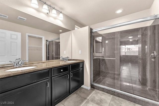 bathroom featuring vanity, tile patterned flooring, and a shower with door