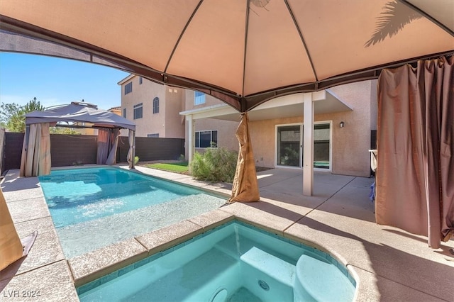 view of pool with a jacuzzi, a gazebo, and a patio