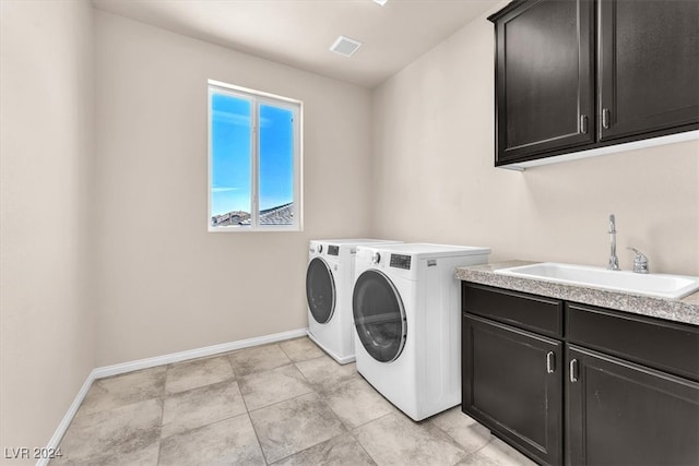 washroom with cabinets, sink, and separate washer and dryer