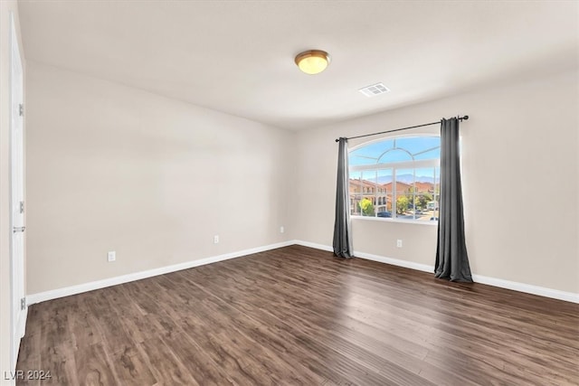 unfurnished room with dark wood-type flooring