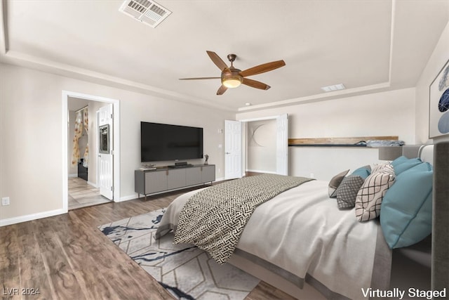 bedroom with hardwood / wood-style floors, ensuite bath, and ceiling fan