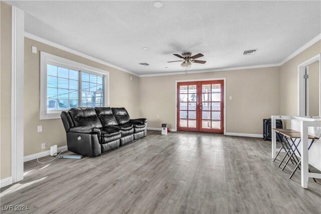 living room featuring ornamental molding, french doors, light hardwood / wood-style floors, and ceiling fan