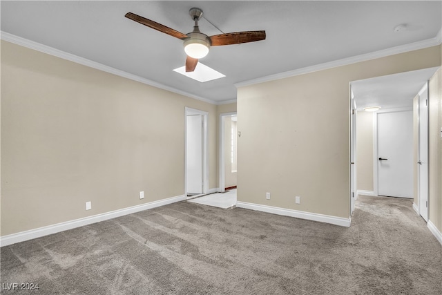 unfurnished bedroom with ornamental molding, a skylight, light carpet, and ceiling fan