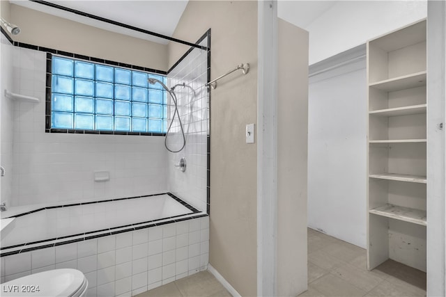 bathroom featuring toilet, tile patterned floors, and tiled shower / bath