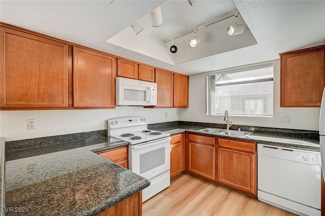 kitchen with sink, track lighting, a tray ceiling, and white appliances