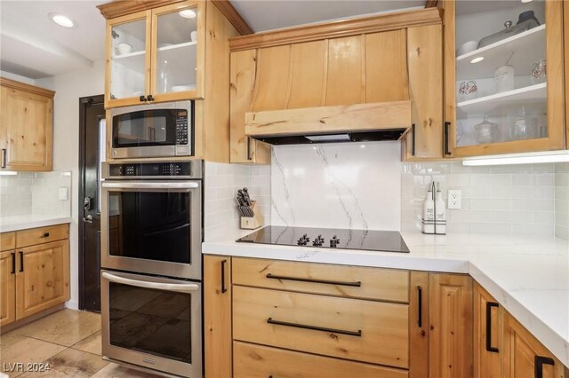 kitchen featuring backsplash, light tile patterned floors, and stainless steel appliances