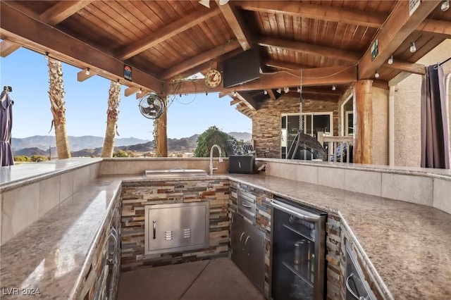 view of patio with a mountain view, wine cooler, and exterior kitchen