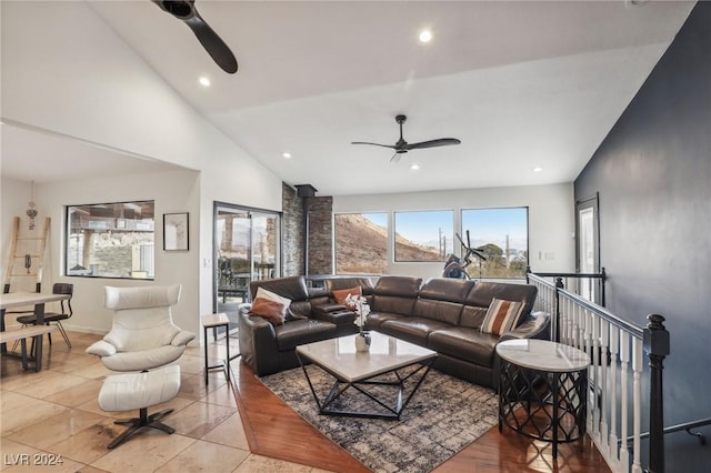 tiled living room featuring ceiling fan and high vaulted ceiling