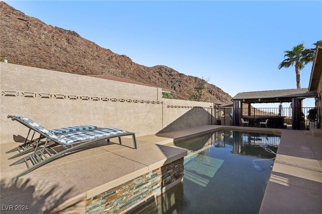 view of swimming pool with a patio area and a mountain view