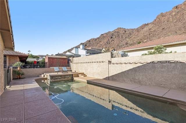 view of patio with a mountain view and a fenced in pool