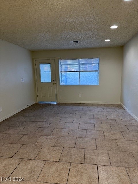 spare room with a textured ceiling