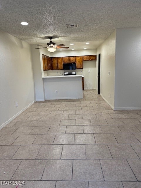 kitchen featuring stainless steel range, kitchen peninsula, a textured ceiling, and ceiling fan