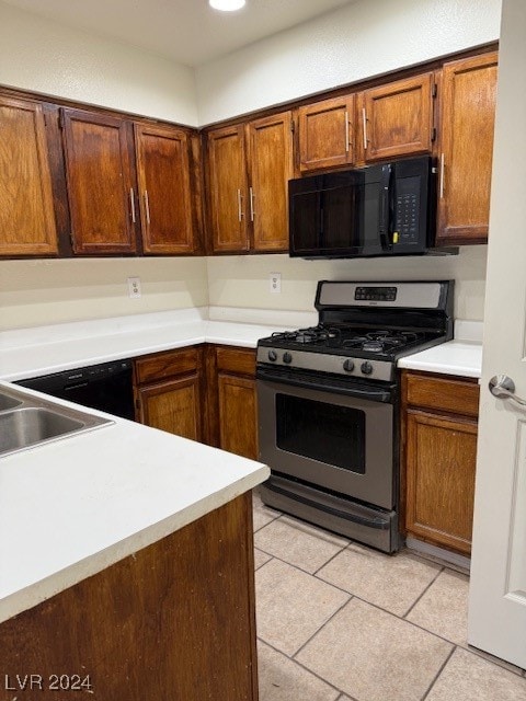 kitchen with gas stove, sink, and light tile patterned floors