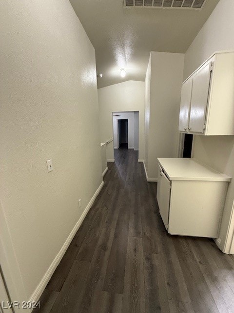 hall featuring vaulted ceiling and dark hardwood / wood-style flooring