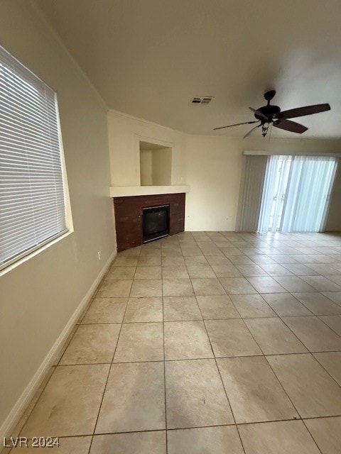 unfurnished living room with ceiling fan, light tile patterned floors, and a wealth of natural light