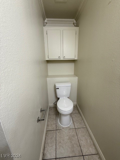 bathroom with ornamental molding, toilet, and tile patterned flooring