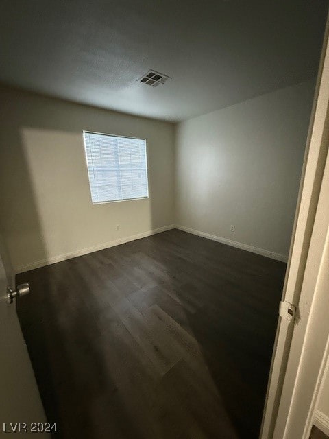 empty room with dark hardwood / wood-style flooring