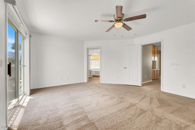 unfurnished room with light colored carpet and ceiling fan