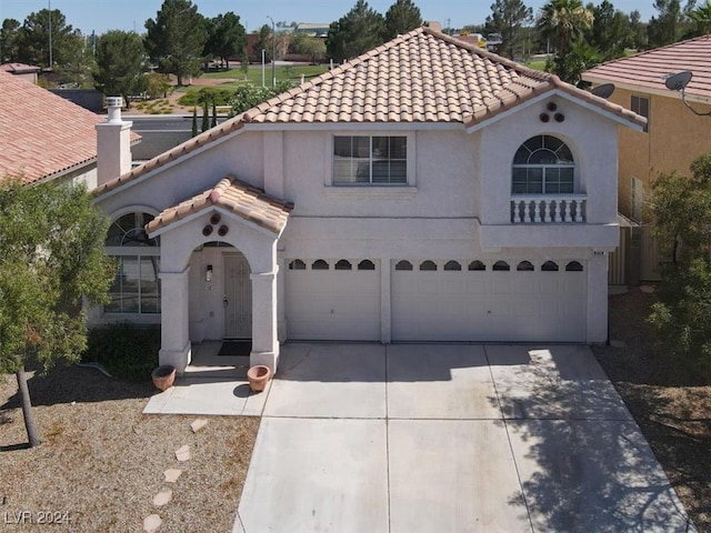 mediterranean / spanish home with a garage