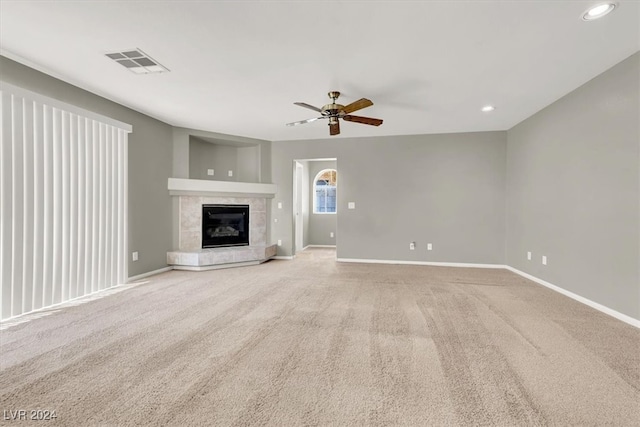 unfurnished living room with light carpet, a fireplace, and ceiling fan