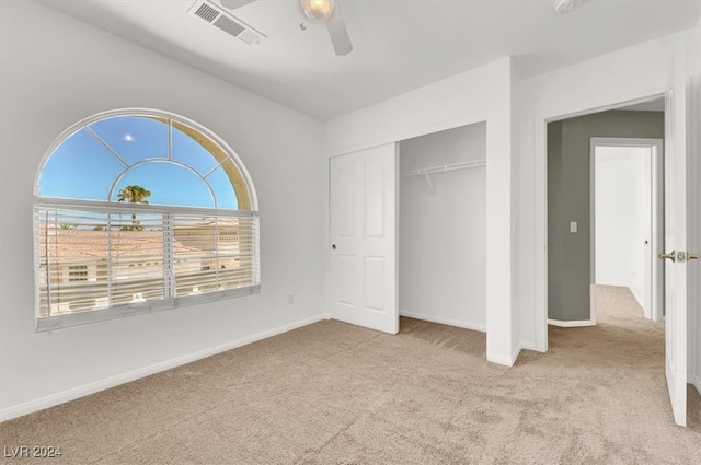 unfurnished bedroom with a closet, ceiling fan, and light carpet