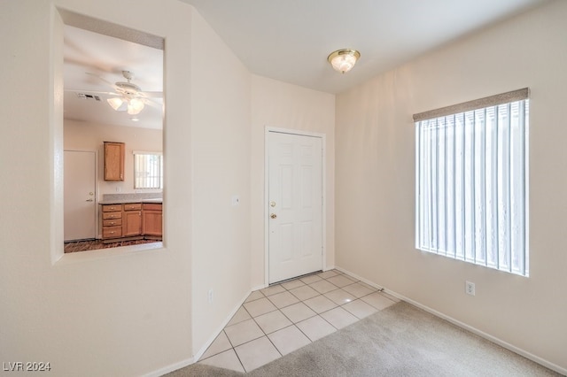 entrance foyer featuring light tile patterned floors and ceiling fan