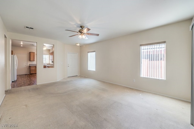 carpeted empty room featuring ceiling fan