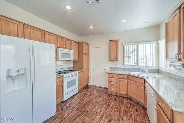 kitchen featuring light stone countertops, white appliances, dark wood-type flooring, and sink