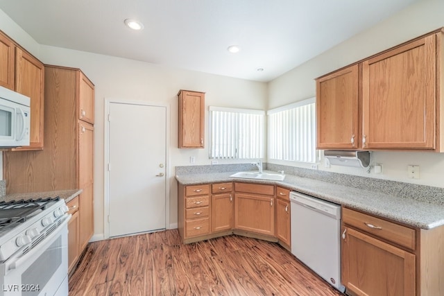 kitchen featuring white appliances, light hardwood / wood-style floors, and sink