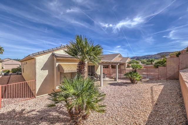 rear view of house featuring a pergola and a patio