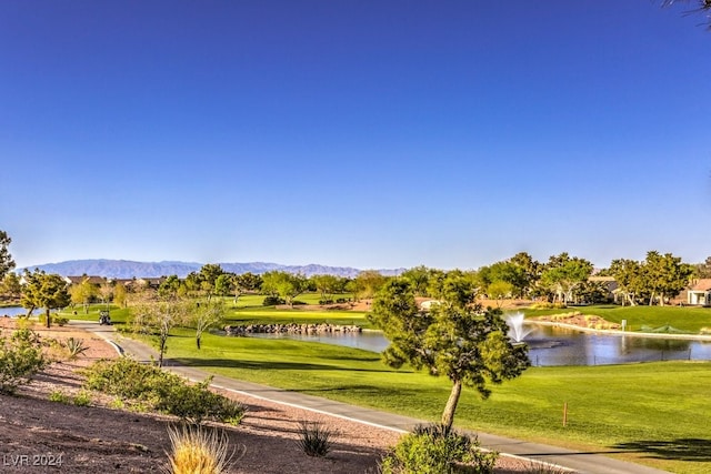 view of property's community with a water and mountain view and a lawn