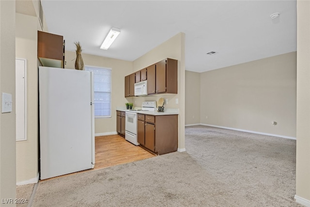 kitchen featuring light wood-type flooring and white appliances