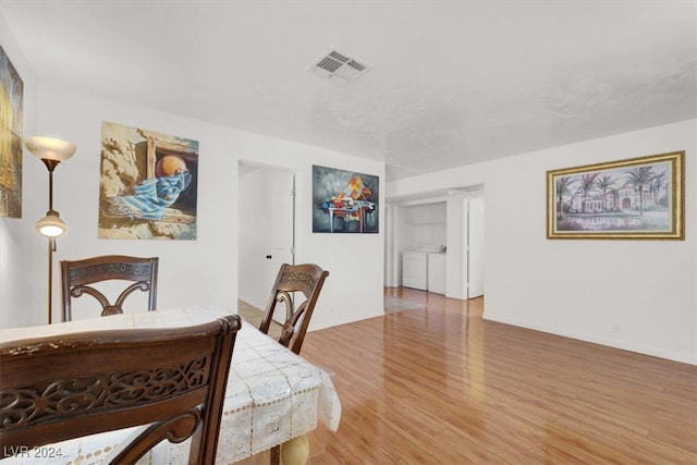 dining space featuring light wood-type flooring and washer and clothes dryer