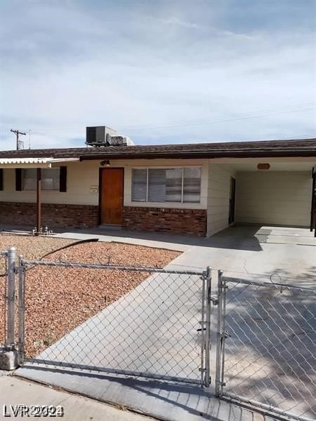 ranch-style house featuring a carport and central AC