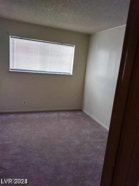 carpeted spare room featuring a textured ceiling