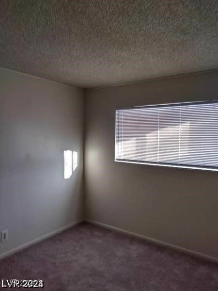 carpeted spare room with a textured ceiling