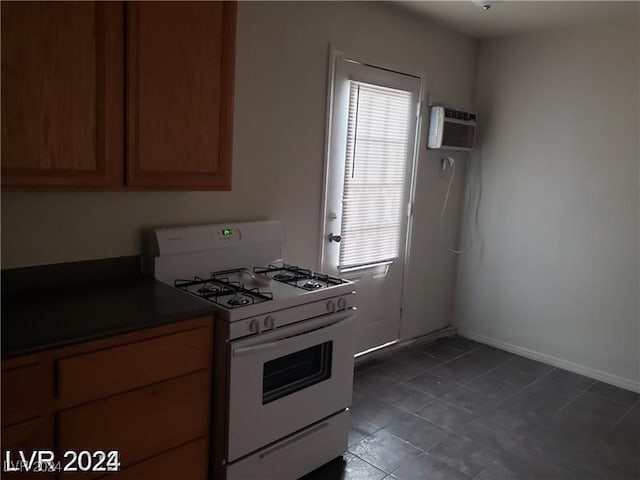 kitchen with white range with gas stovetop and an AC wall unit